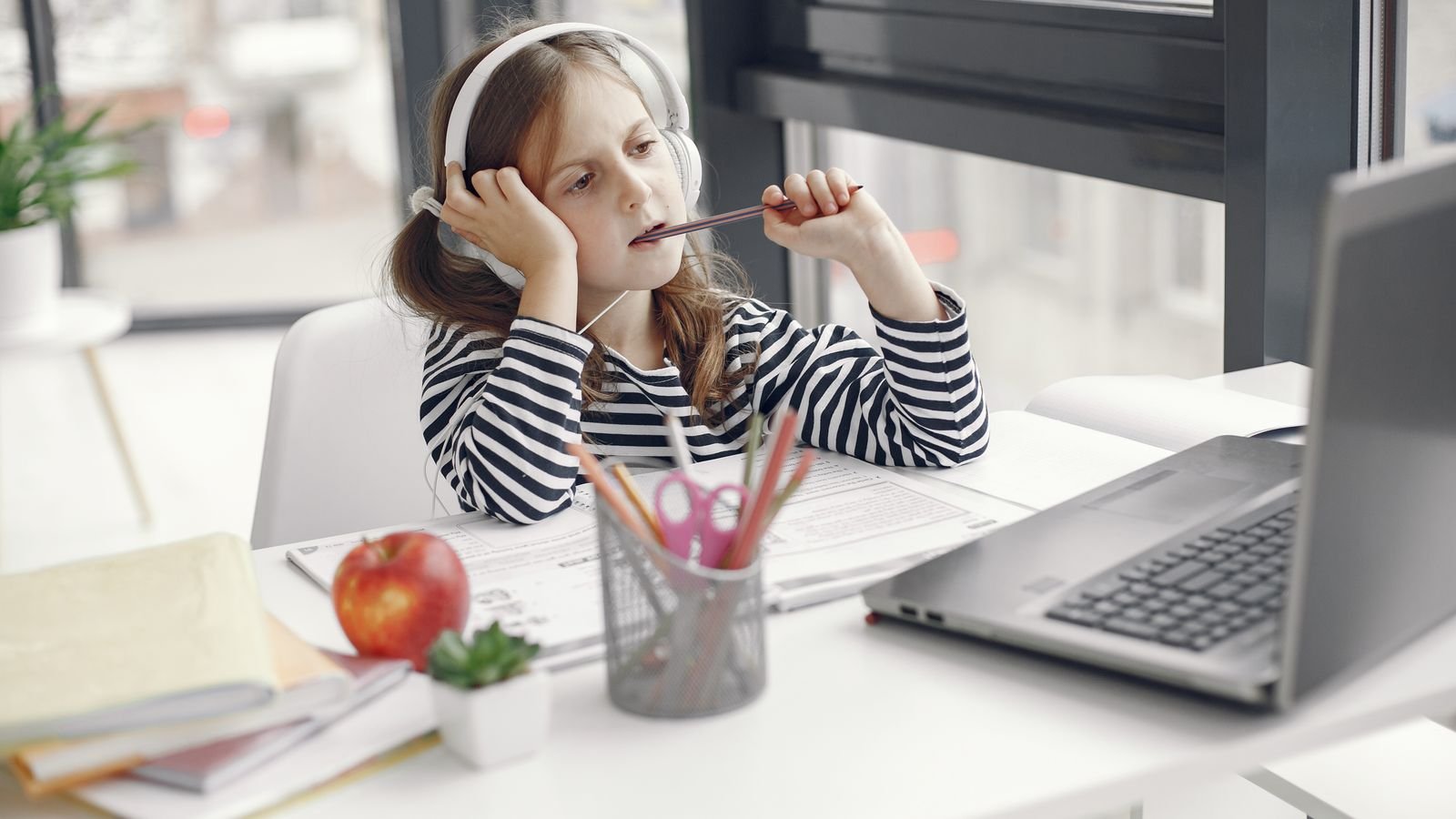 Child taking a live online class on a laptop, an example of active screen time for kids