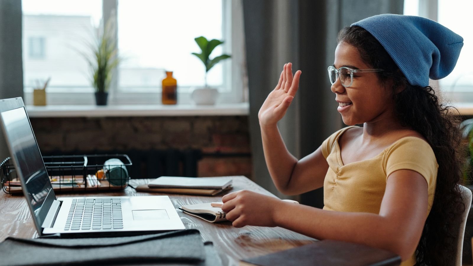 Young child smiling at a laptop during a free trial chess class online
