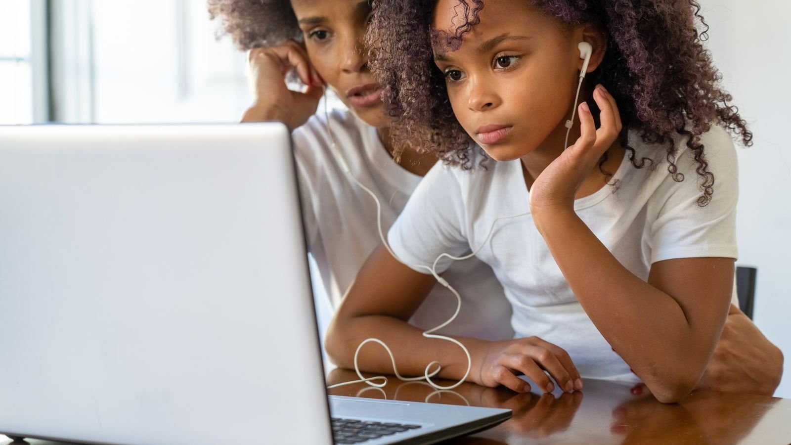 Parent watching a child take a live 1 on 1 online chess lesson at home