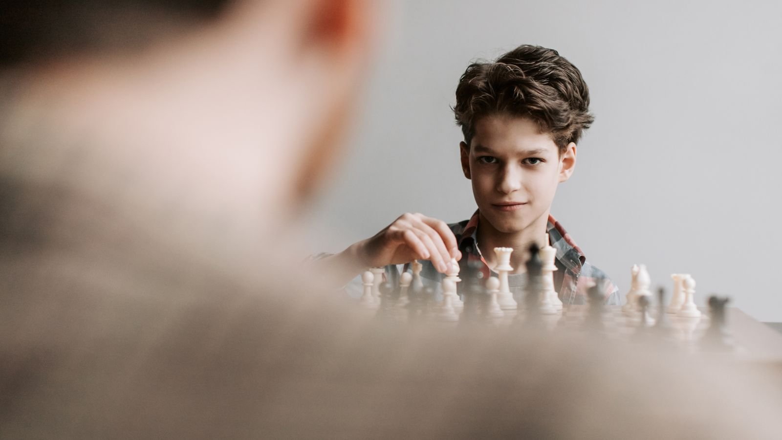 Child concentrating over a chessboard during a chess lesson for kids