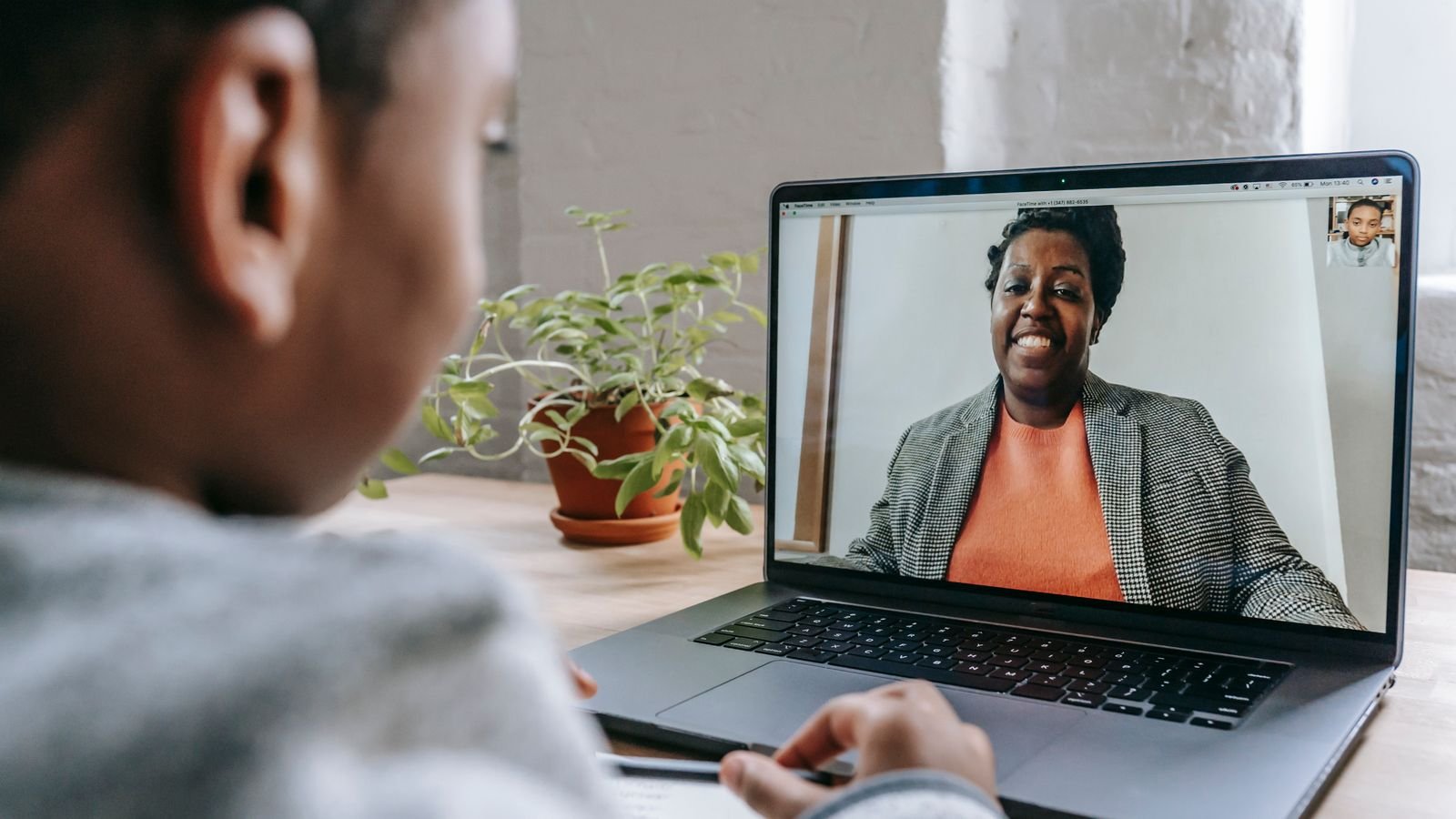 Child talking to a teacher during a live 1 on 1 online trial class on a laptop