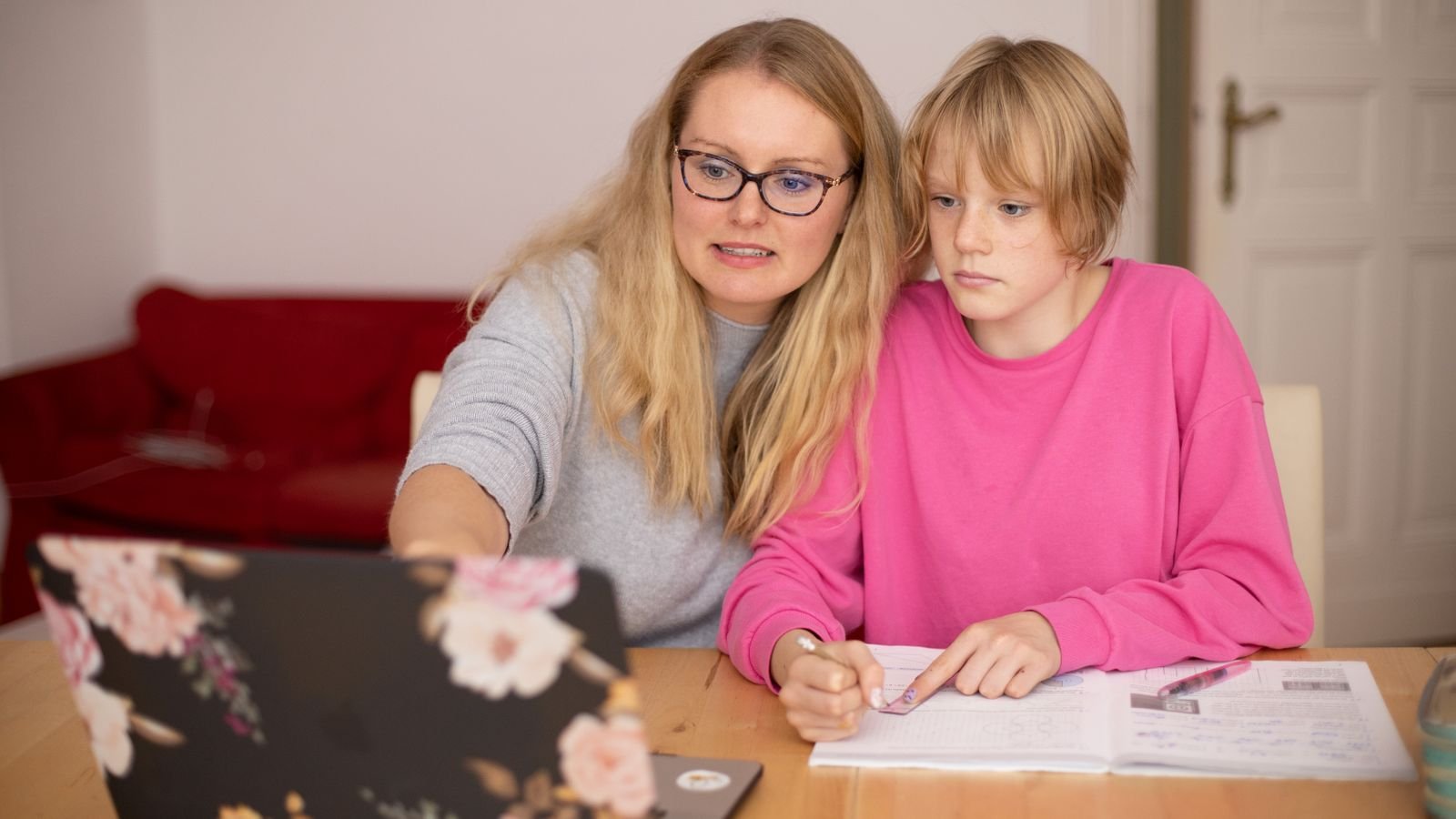 Parent watching a child take an online 1 on 1 tutoring session at home on a laptop