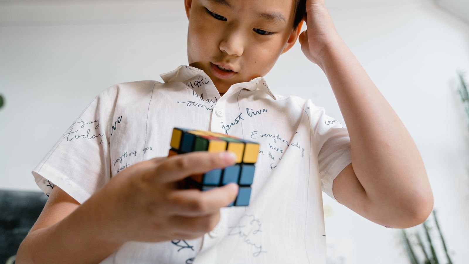 Child learning Rubik's cube algorithms in a live 1 on 1 online class on a laptop