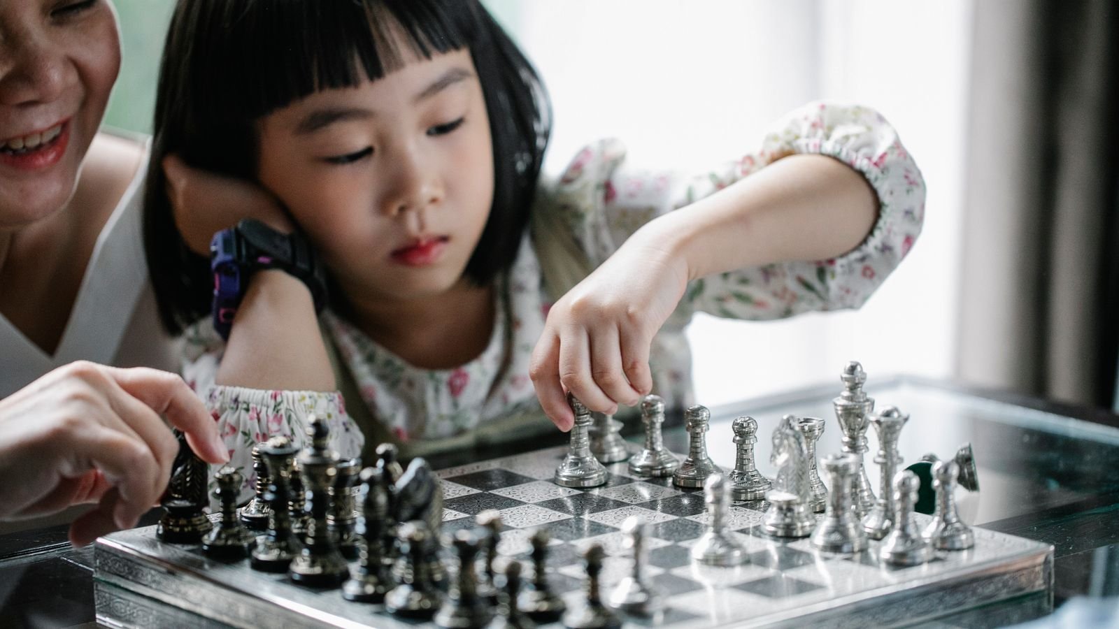 Parent and child reviewing a chess game together at home before a first chess tournament