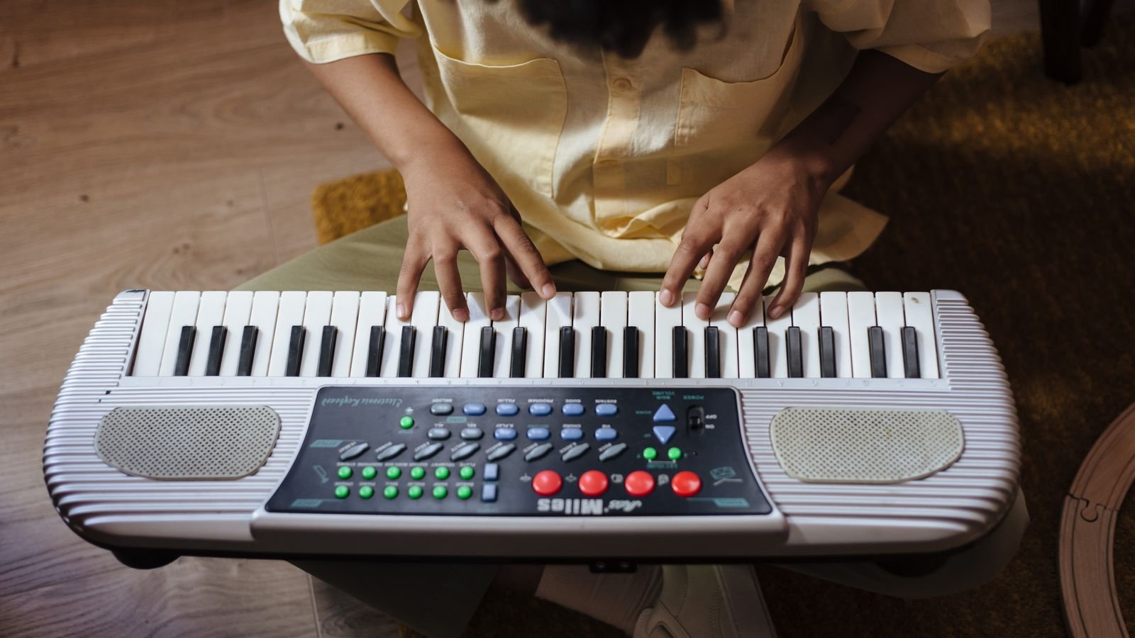 Young child concentrating at a piano during a beginner music lesson at home