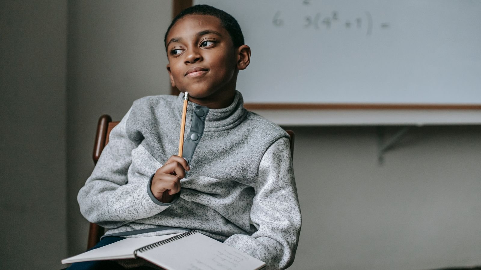 Child thinking carefully while working through a problem at a desk, building skills for an AI driven future