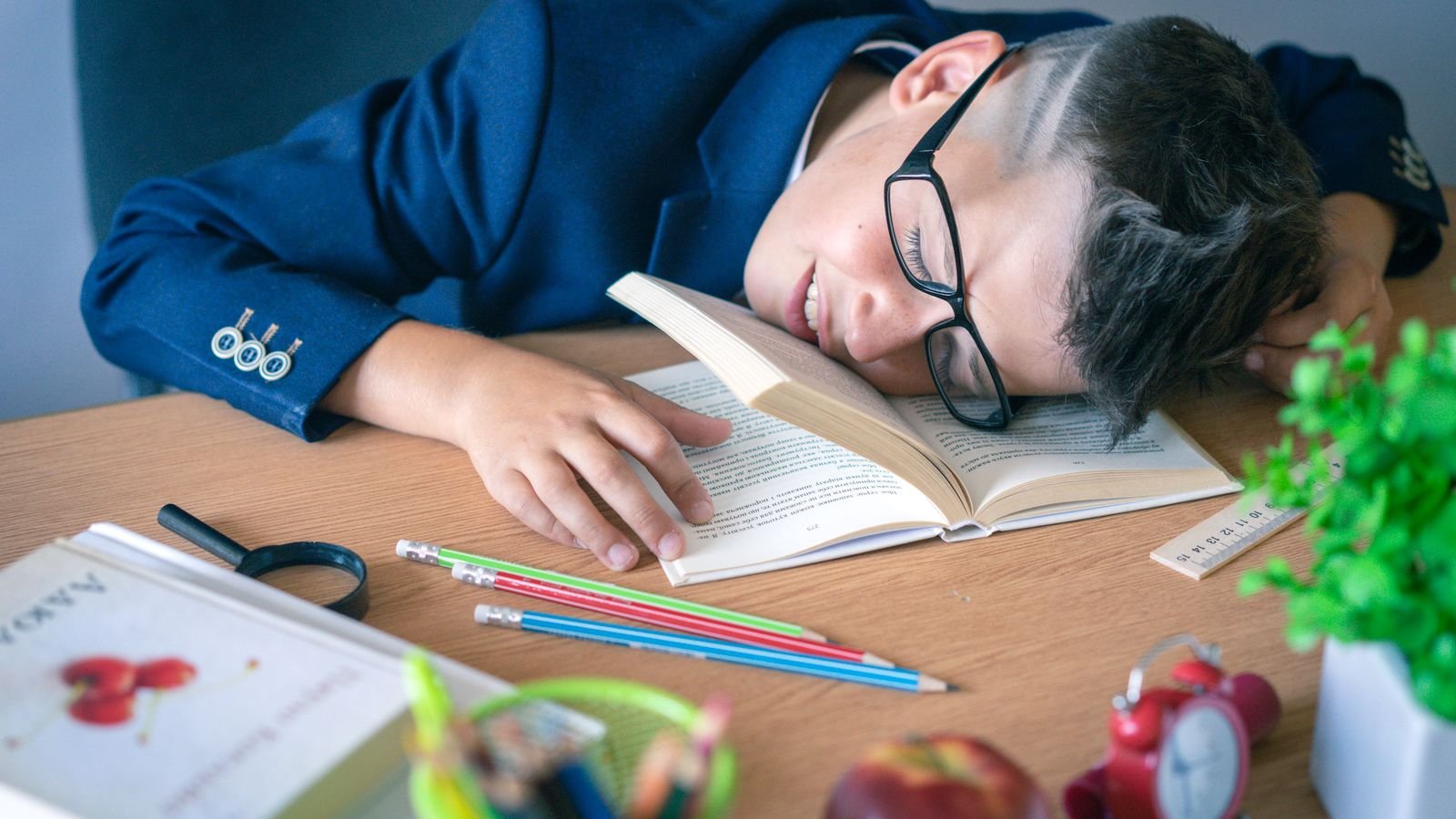 School-age child at a home desk with a weekly planner, learning time management for kids
