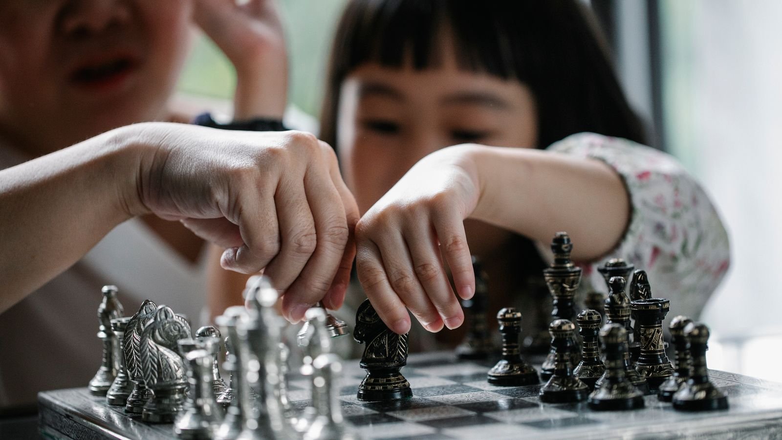 Young child concentrating over a chess board, learning what chess teaches kids beyond school