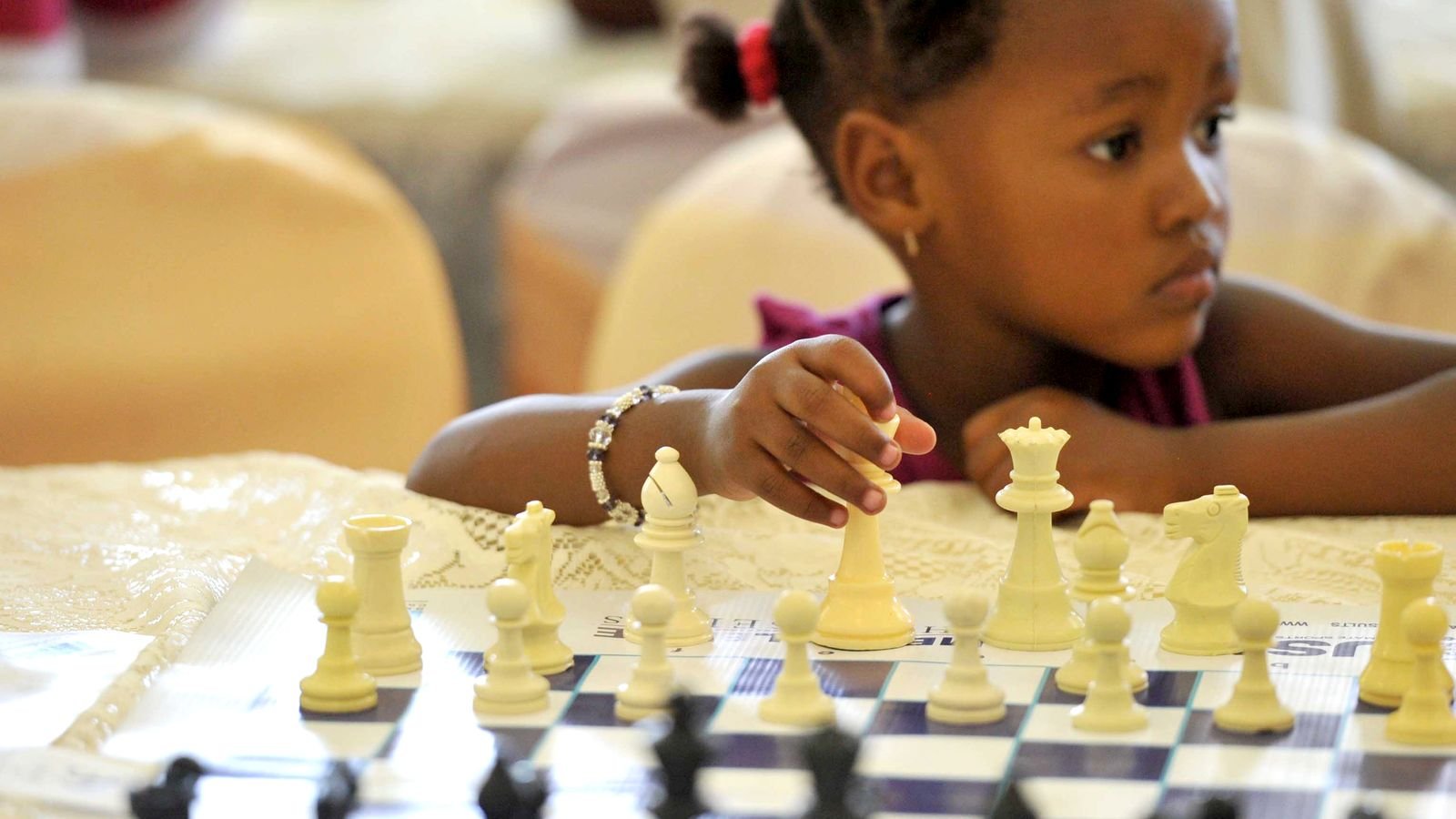 Child concentrating during a friendly competition, building confidence through effort rather than winning