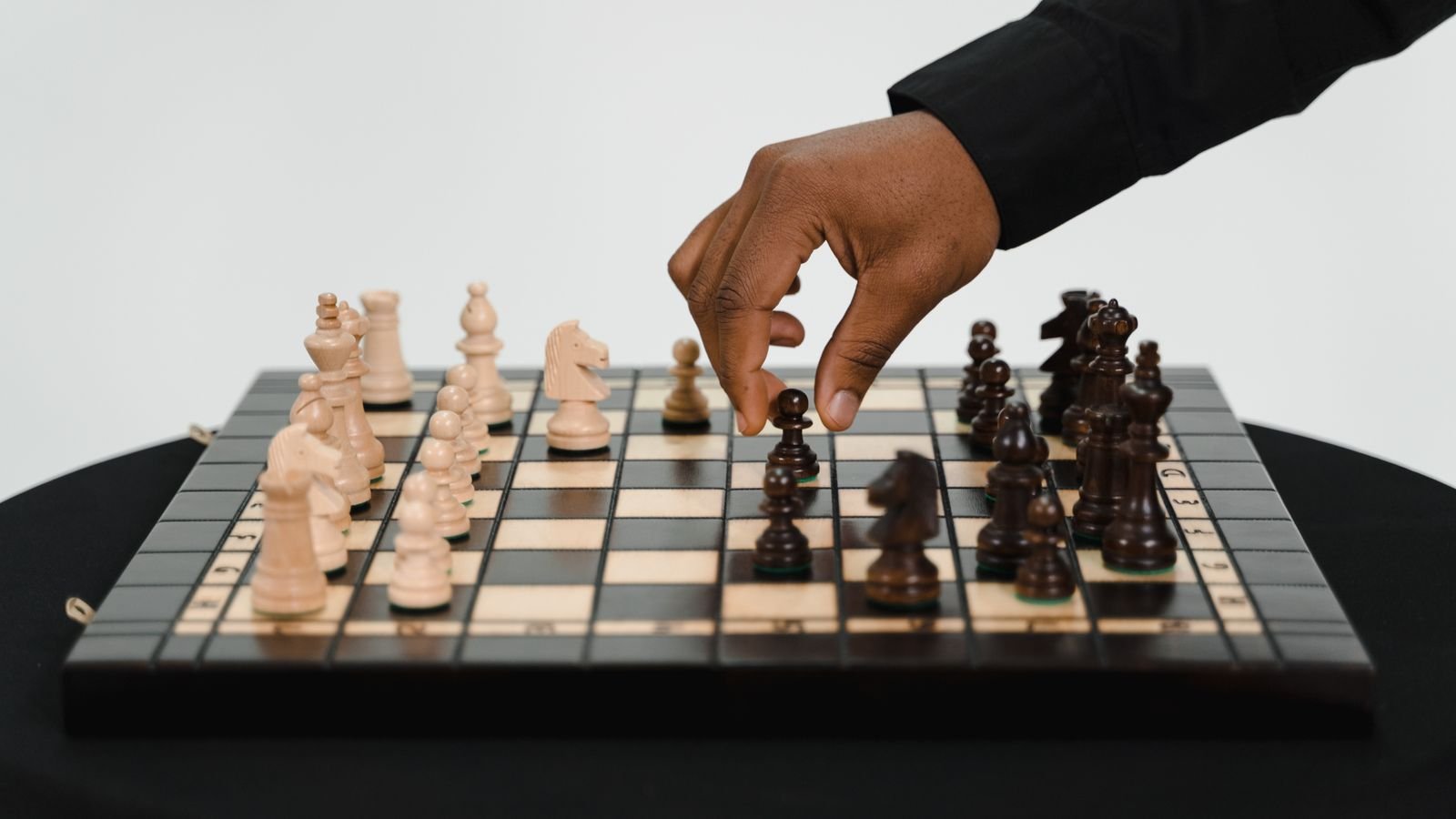 Child concentrating on a chess endgame with only a few pieces left on the board