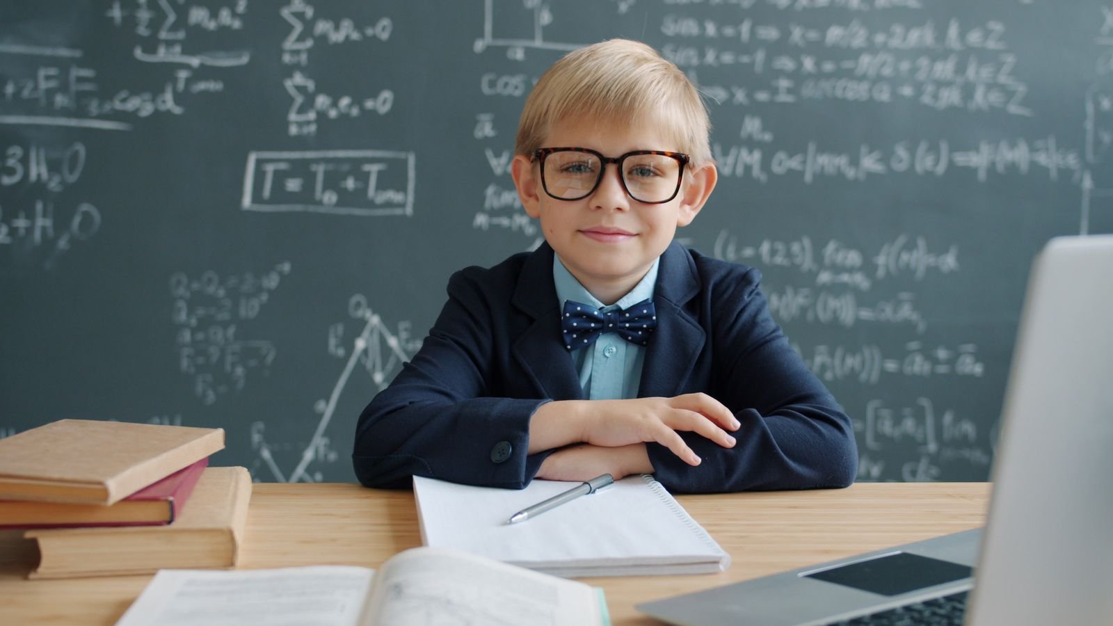 Child aged around nine working out a mental maths sum in their head, thinking with pencil and paper nearby