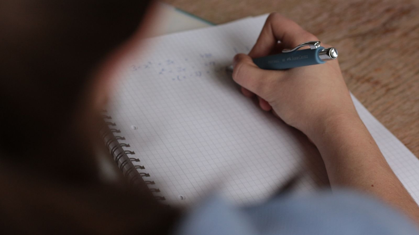 Primary school child in Singapore working through a PSLE maths past paper at home