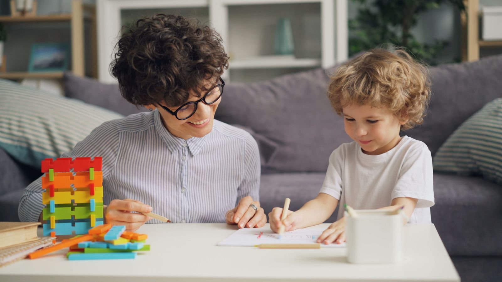 Parent and child reviewing a marked PSLE maths paper and model drawing together at home