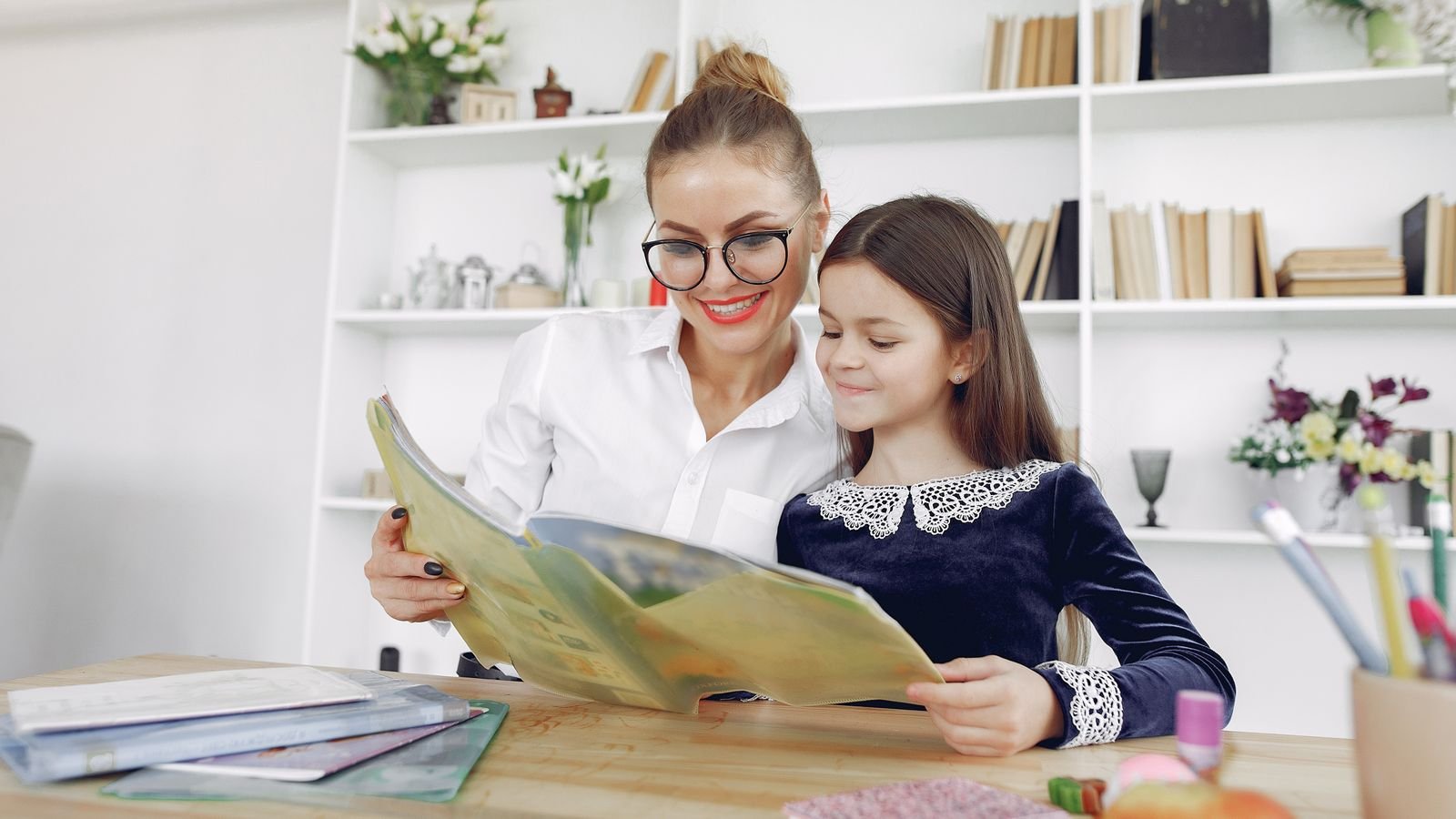 Parent and child reviewing a progress notebook together to check if online classes are working