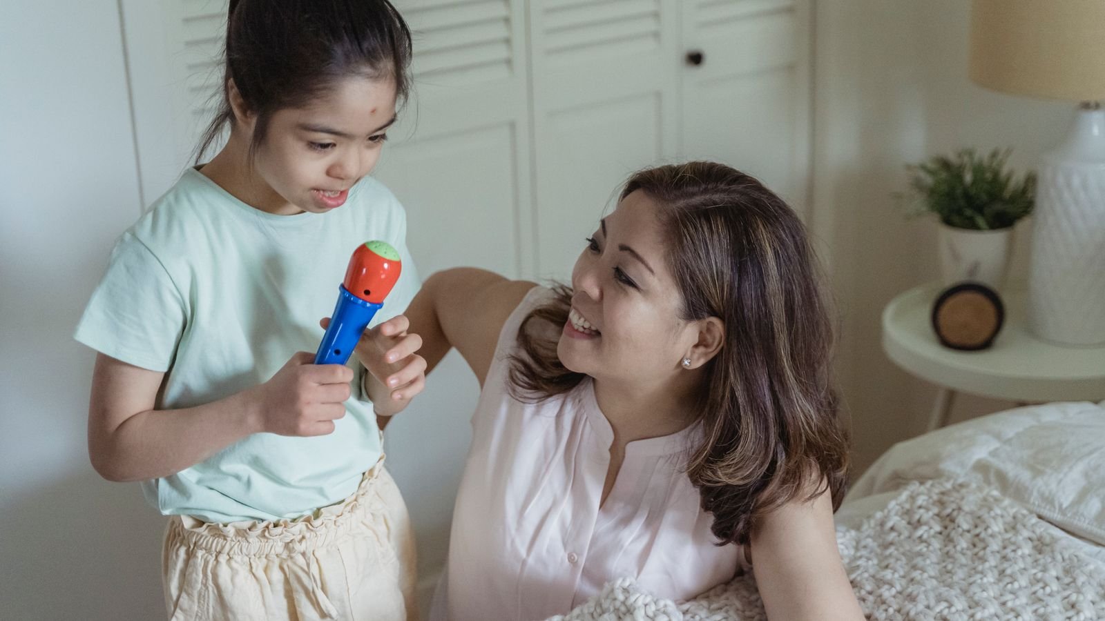 Parent talking calmly at eye level with a shy child before an online class